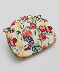Spindle shaped chair pads with a multicoloured fruit design on a beige base